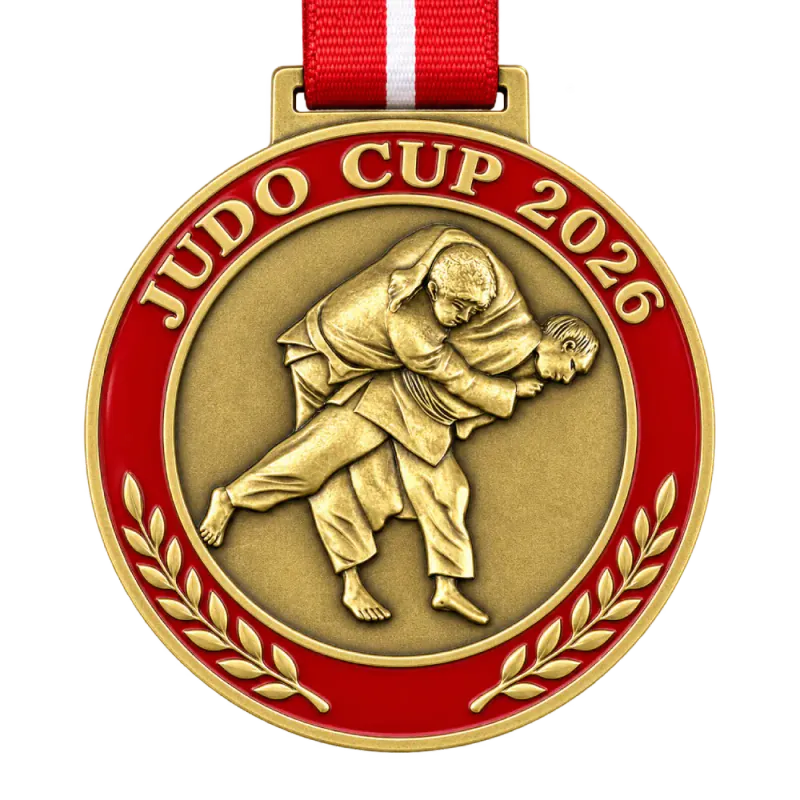 Cast 3D judo medal: two judoka mid-throw in high relief, red enamel ring and the text JUDO CUP 2026, on a red ribbon