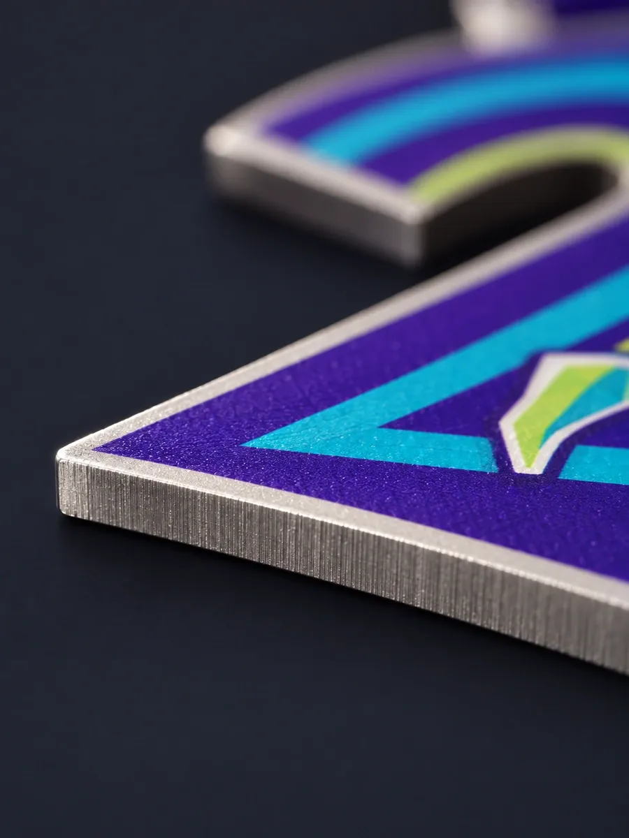 Close-up of the laser-cut edge of a printed steel medal